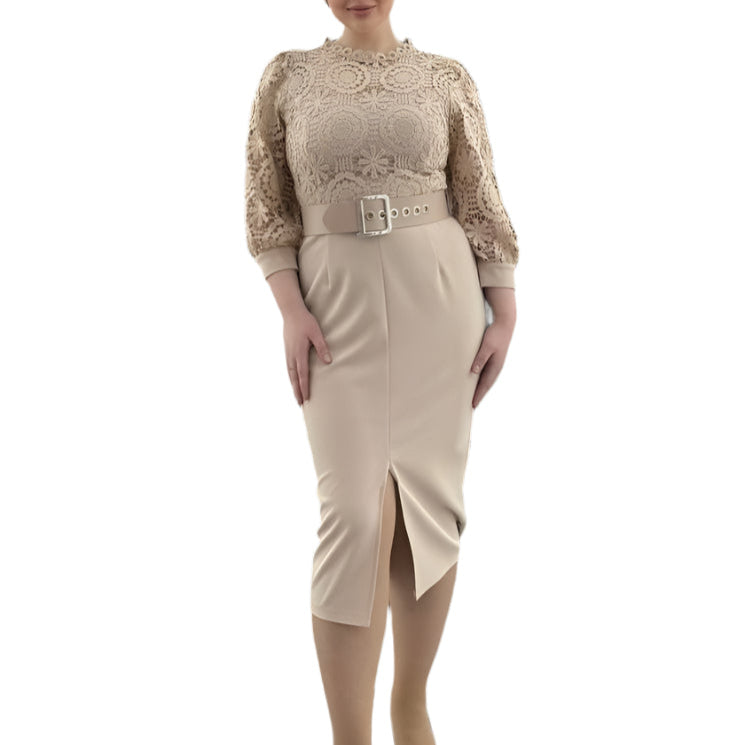 Moteris dėvi elegantišką kūno spalvos suknelę su nėriniuotu viršumi, diržu ir skeltuku priekyje – pritaikyta šventėms.