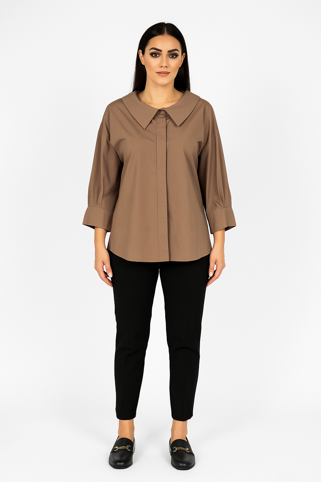 Woman wearing a brown blouse and black pants on a white background