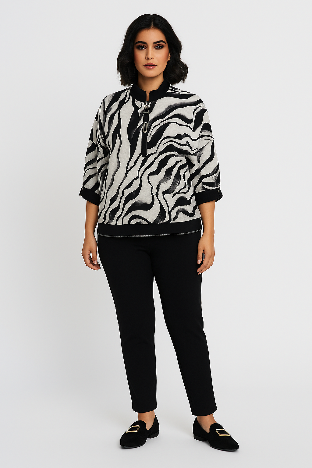 Woman wearing a black and white zebra print jacket with black pants on a white background