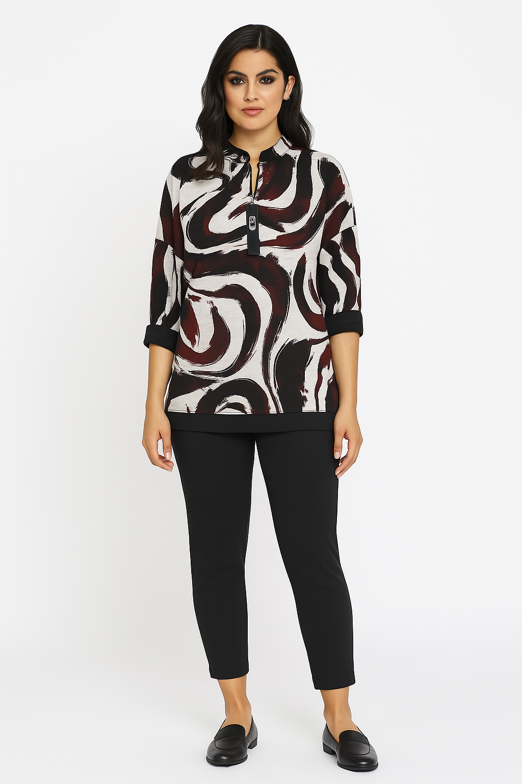 Woman wearing a patterned blouse and black pants on a white background