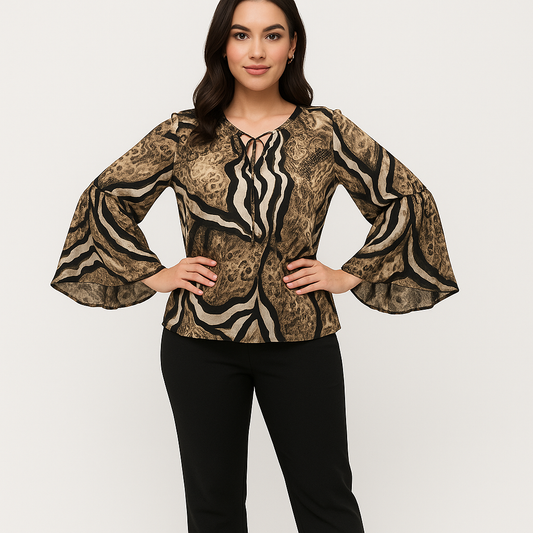 Woman wearing a patterned blouse with bell sleeves on a plain background