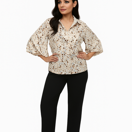 Woman wearing a patterned blouse and black pants on a white background