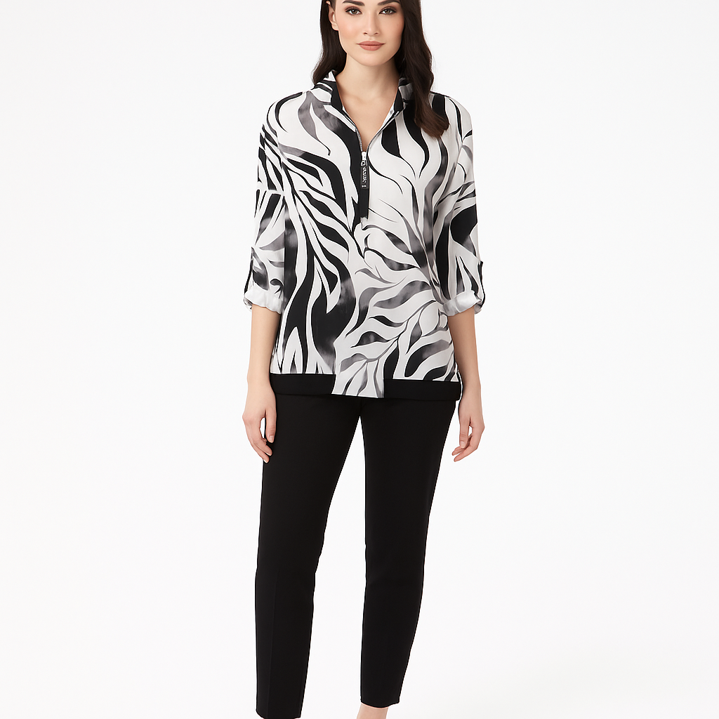 Woman wearing a black and white patterned blouse with black pants on a white background