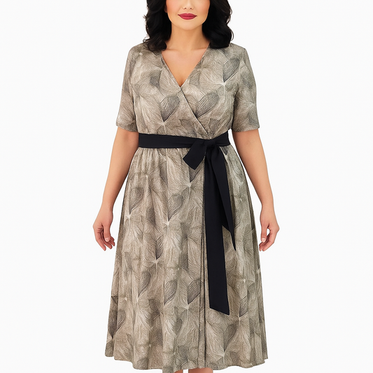 Woman wearing a patterned dress with a black belt on a white background