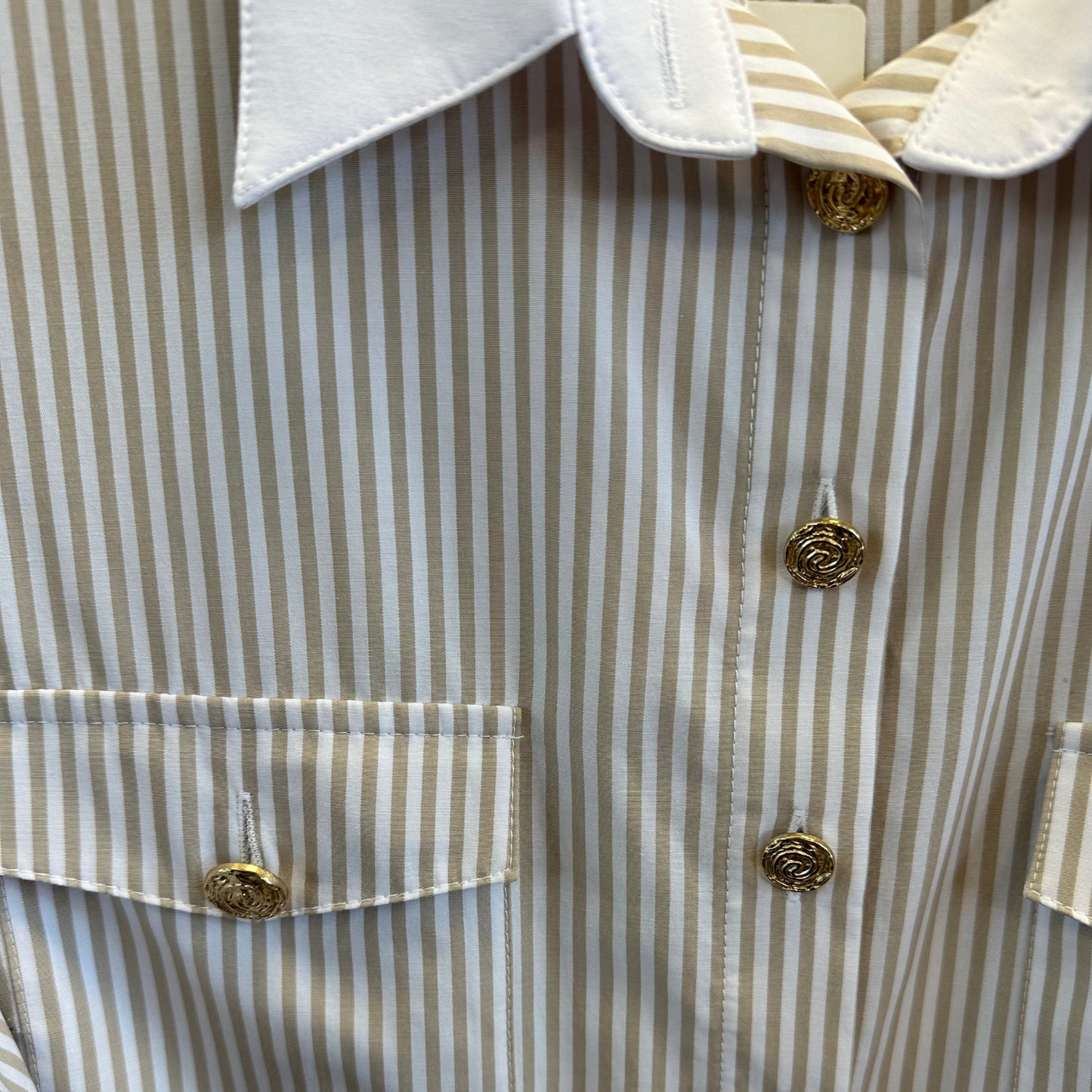 Auksinės sagos ir dvi krūtinės kišenės pabrėžia marškinių prabangų dizainą.

