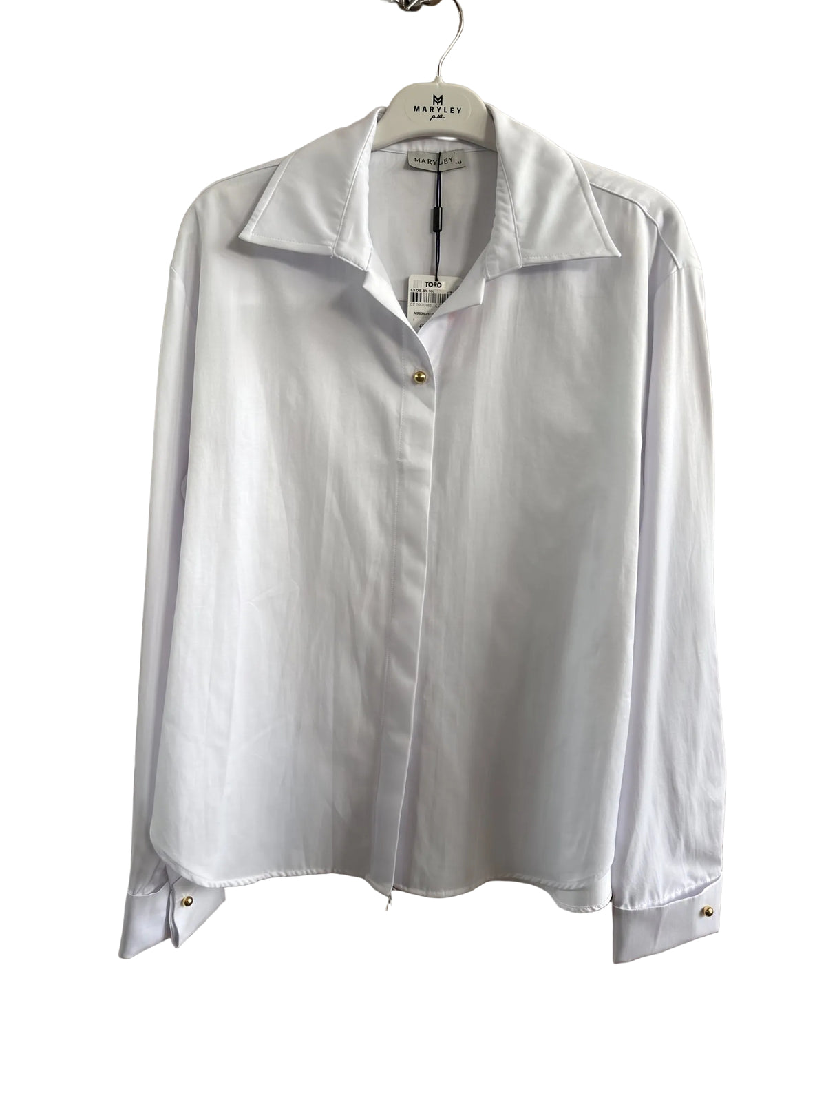 A white long-sleeve button-up shirt with a pointed collar and small gold-tone buttons, hanging on a white hanger against a light brown wooden door.