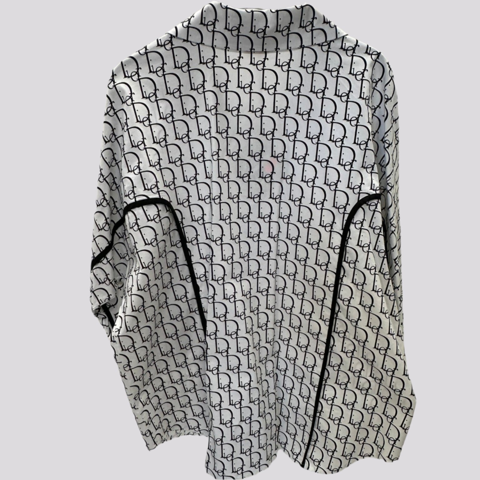 Balti moteriški marškiniai su raštu, pakabinti ant pakabos, matomas visas priekis.