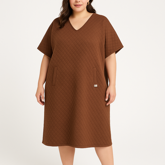 Modelis dėvi rudą oversized suknelę su rombiniu raštu, V formos iškirpte ir kišenėmis, dydis 1, vaizdas iš priekio