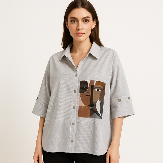 Modelis dėvi dryžuotus marškinius su abstrakčiu moters veido spaudu priekyje.