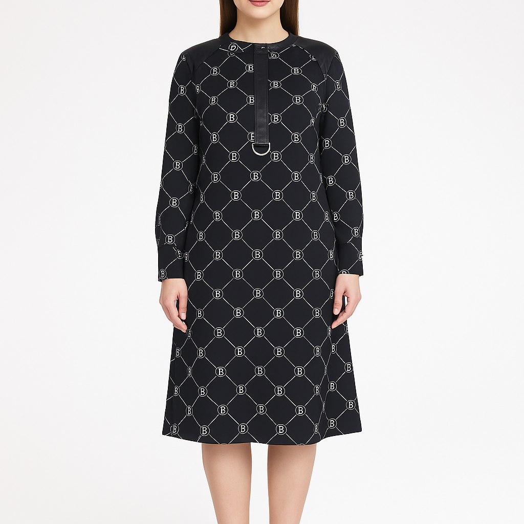 Modelis dėvi juodą suknelę su B raštu, ilgomis rankovėmis ir tiesiu siluetu, dydis 36, vaizdas iš priekio