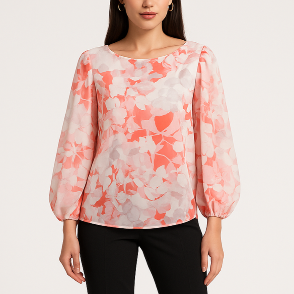 Modelis dėvi gėlėtą palaidinę su ilgomis pūstomis rankovėmis.