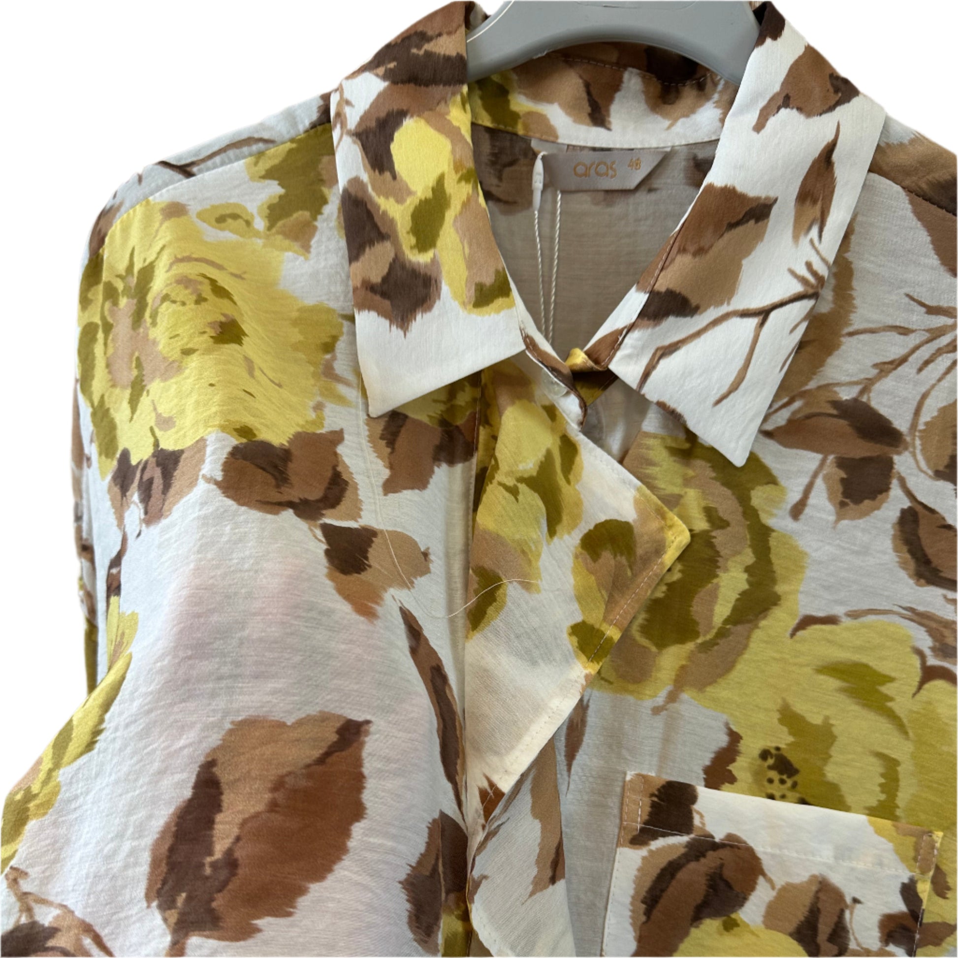 Palaidinė su sagutėmis ir kišenėle priekyje, laisvo silueto, matoma ant pakabos.