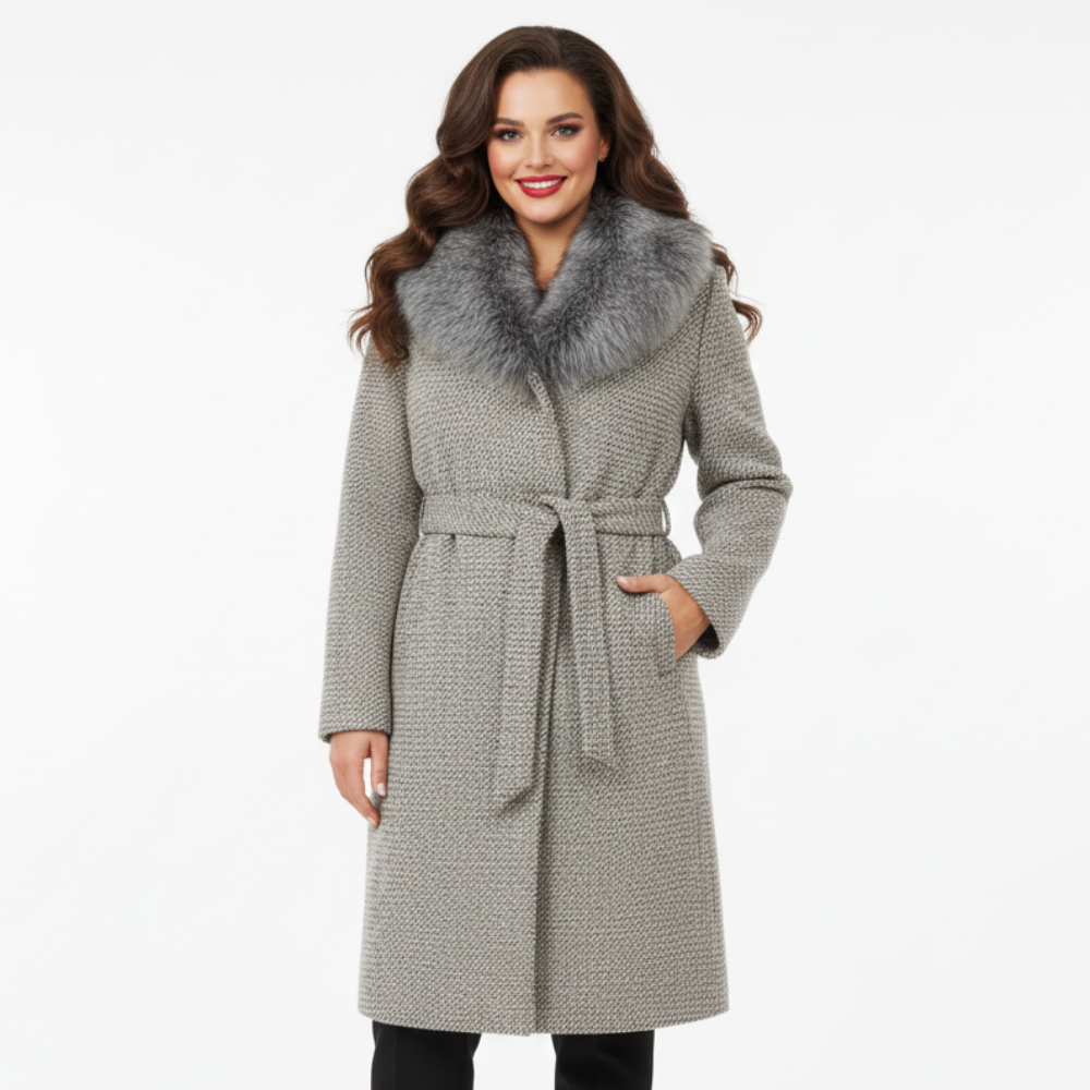 Moteris dėvi pilką paltą su kailine apykakle ir diržu, elegantiškas rudens–žiemos modelis