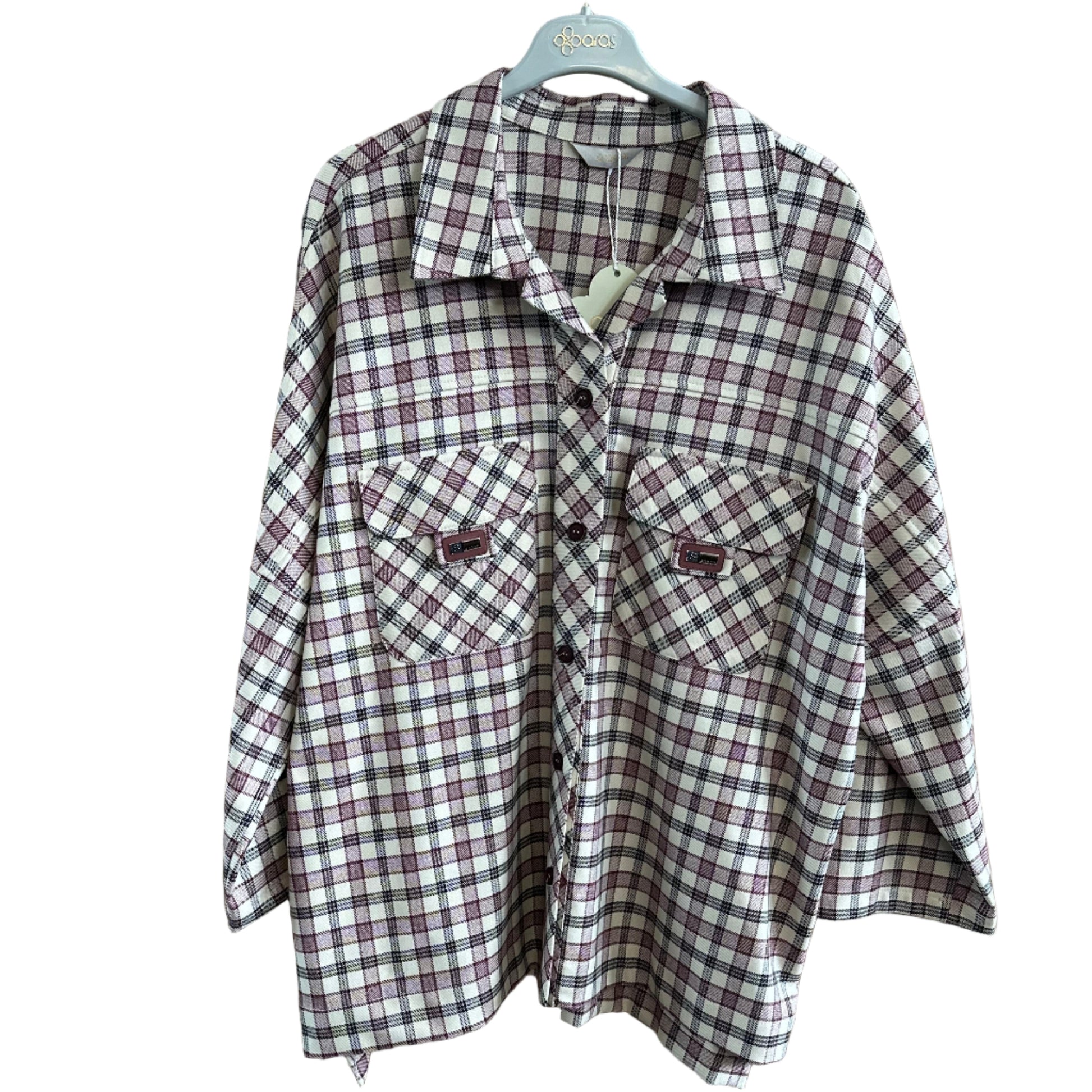 Folded plaid shirt on a wooden surface with a hanger.