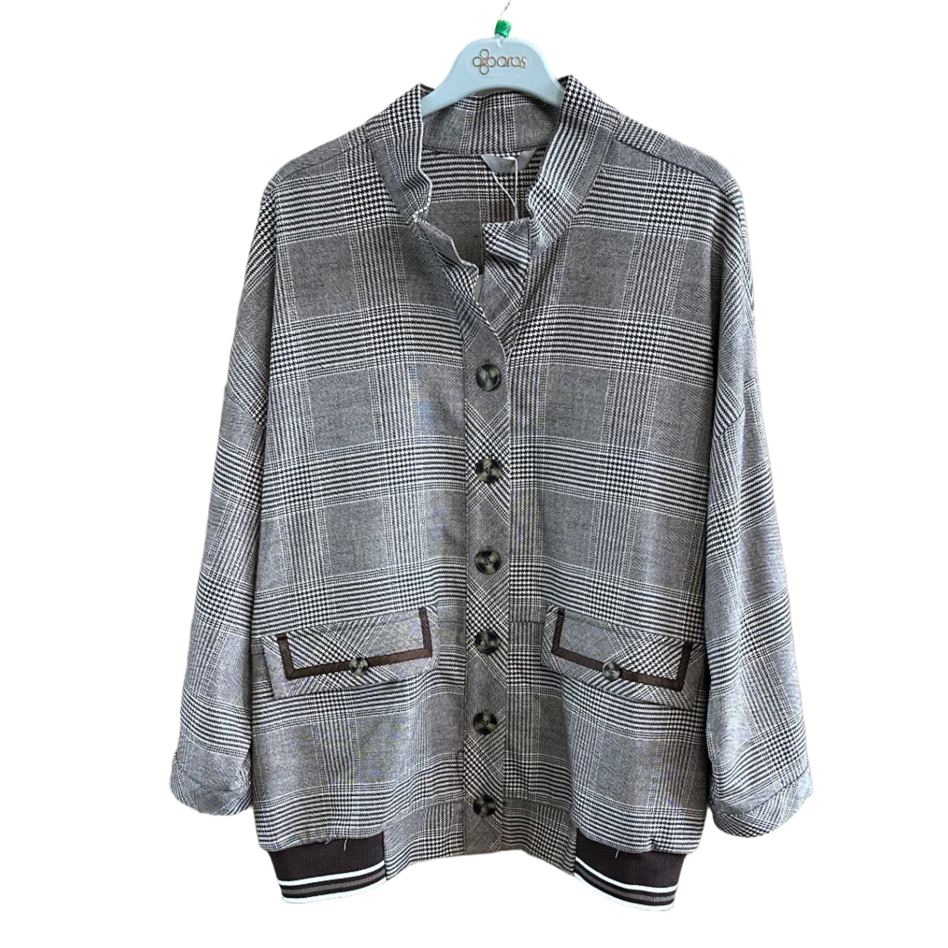 Folded gray jacket on a wooden surface with a blurred background