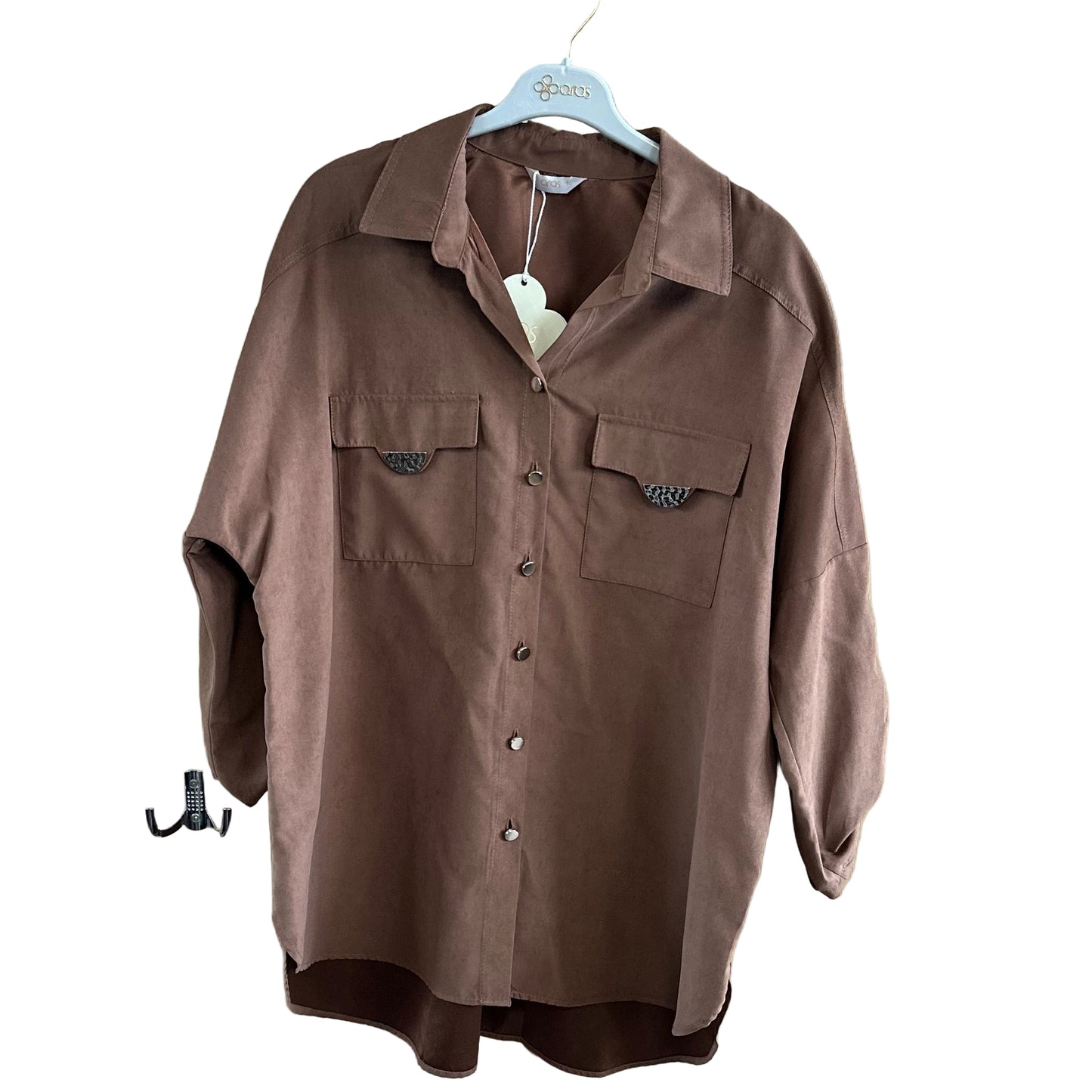 Artimas vaizdas – elegantiški rudi marškiniai su dekoratyviniais metaliniais akcentais.