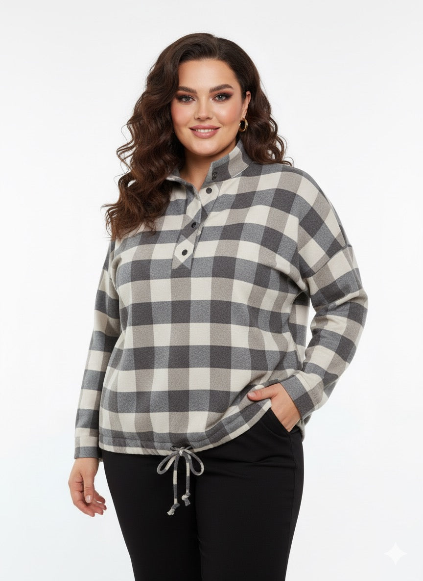 Modelis dėvi pilkai smėlio languotus šiltus marškinius su stovinčia apykakle ir šniūreliu apačioje.