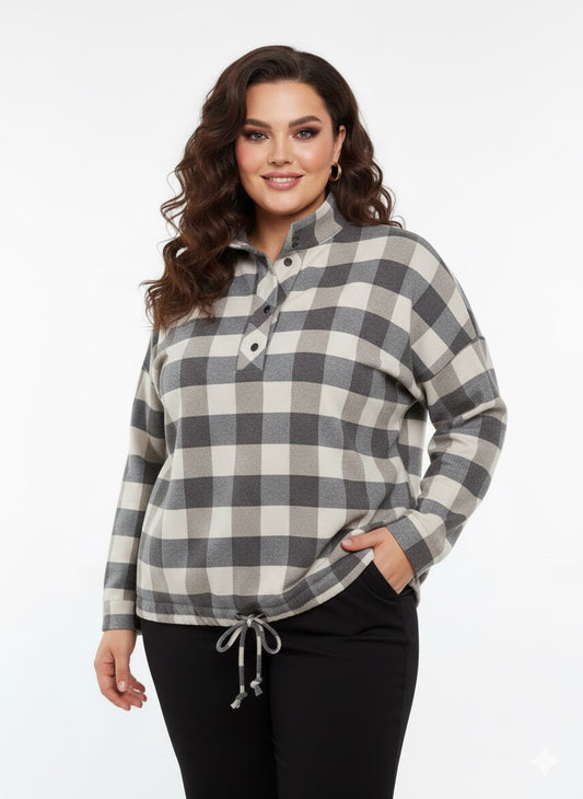 Modelis dėvi pilkai smėlio languotus šiltus marškinius su stovinčia apykakle ir šniūreliu apačioje.