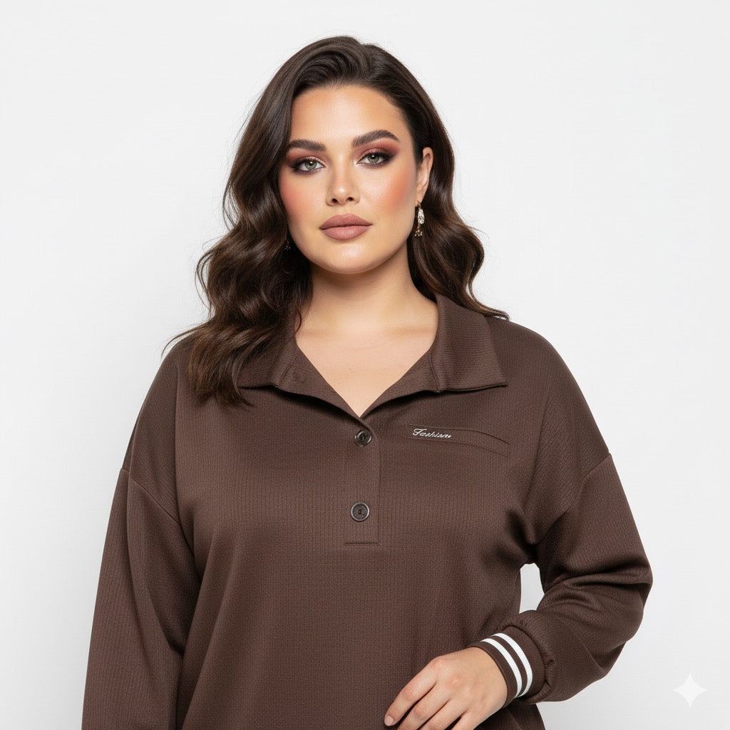 Modelis dėvi rudą palaidinę su sagomis priekyje ir kontrastiniais rankogaliais, matomas viršutinis siluetas.