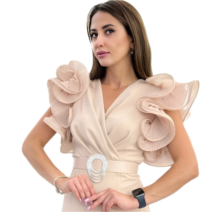 Moteris vilki kūno spalvos ilga suknelę su dekoratyviniais raukiniais pečių srityje ir juosmens diržu su žėručiu