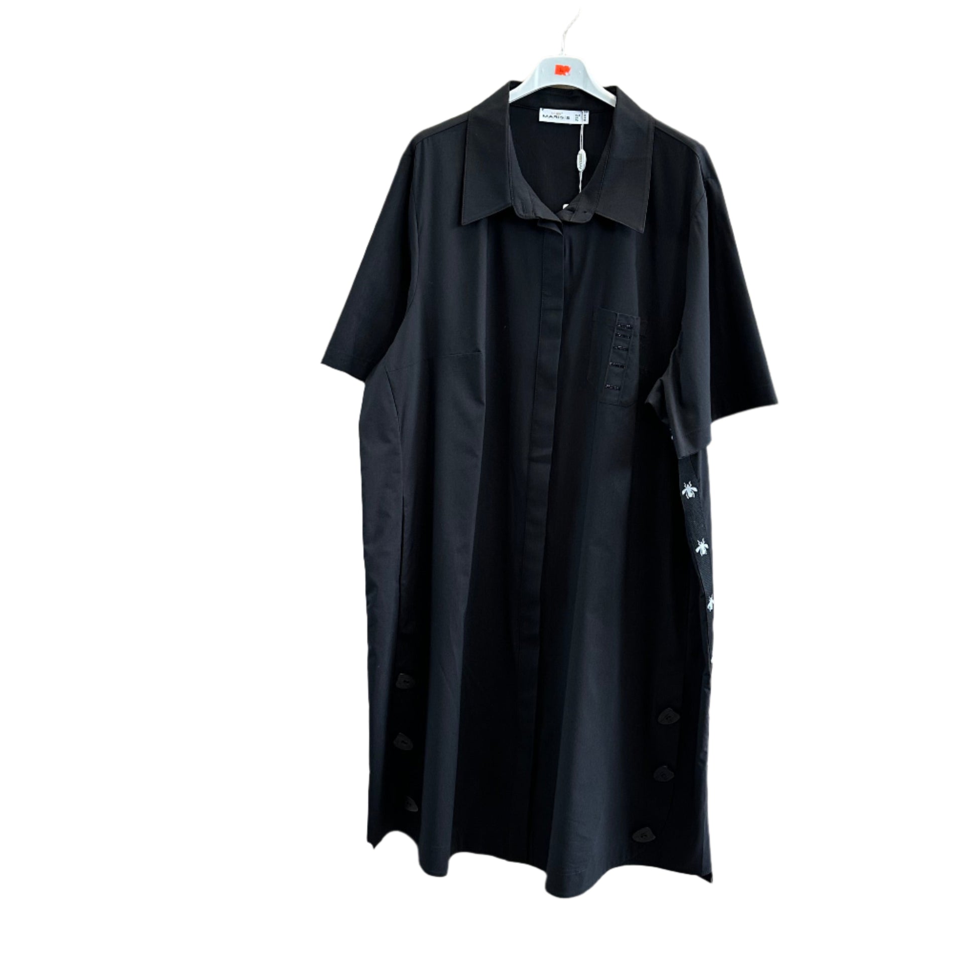 Juoda marškinė tipo suknelė su siuvinėtomis bitutėmis šone ir paslėptu sagų užsegimu, kabanti ant pakabos.