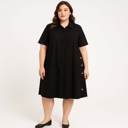 Juoda marškinė tipo suknelė su siuvinėtomis bitutėmis šone ir paslėptu sagų užsegimu, modelis šviesioje patalpje