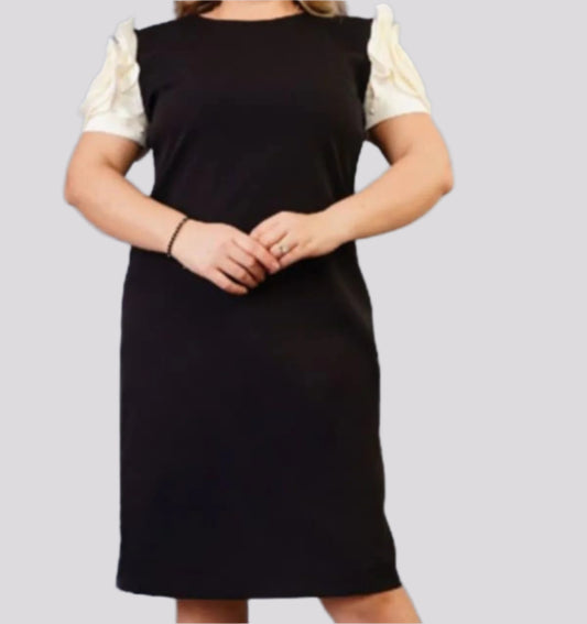 Elegantiška vienspalvė suknelė iki kelių su baltos gėlės dekoruota rankove.