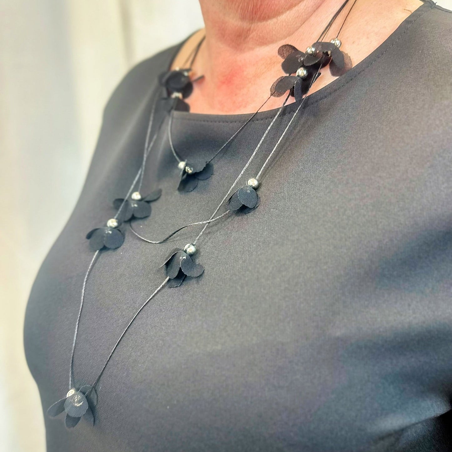 Prie suknelės pridedamas kaklo papuošalas, lengvas , subtilus