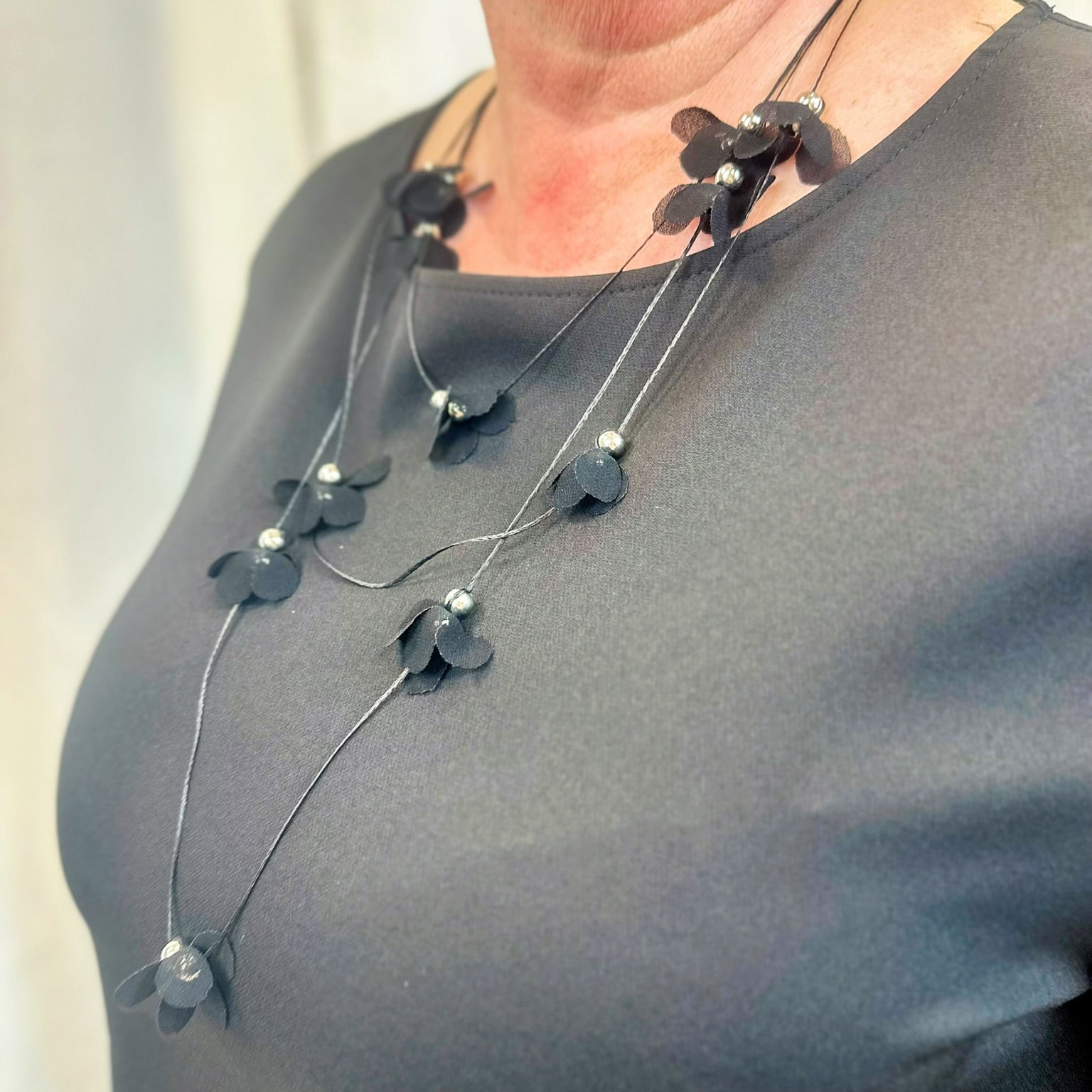 Prie suknelės pridedamas kaklo papuošalas, lengvas , subtilus