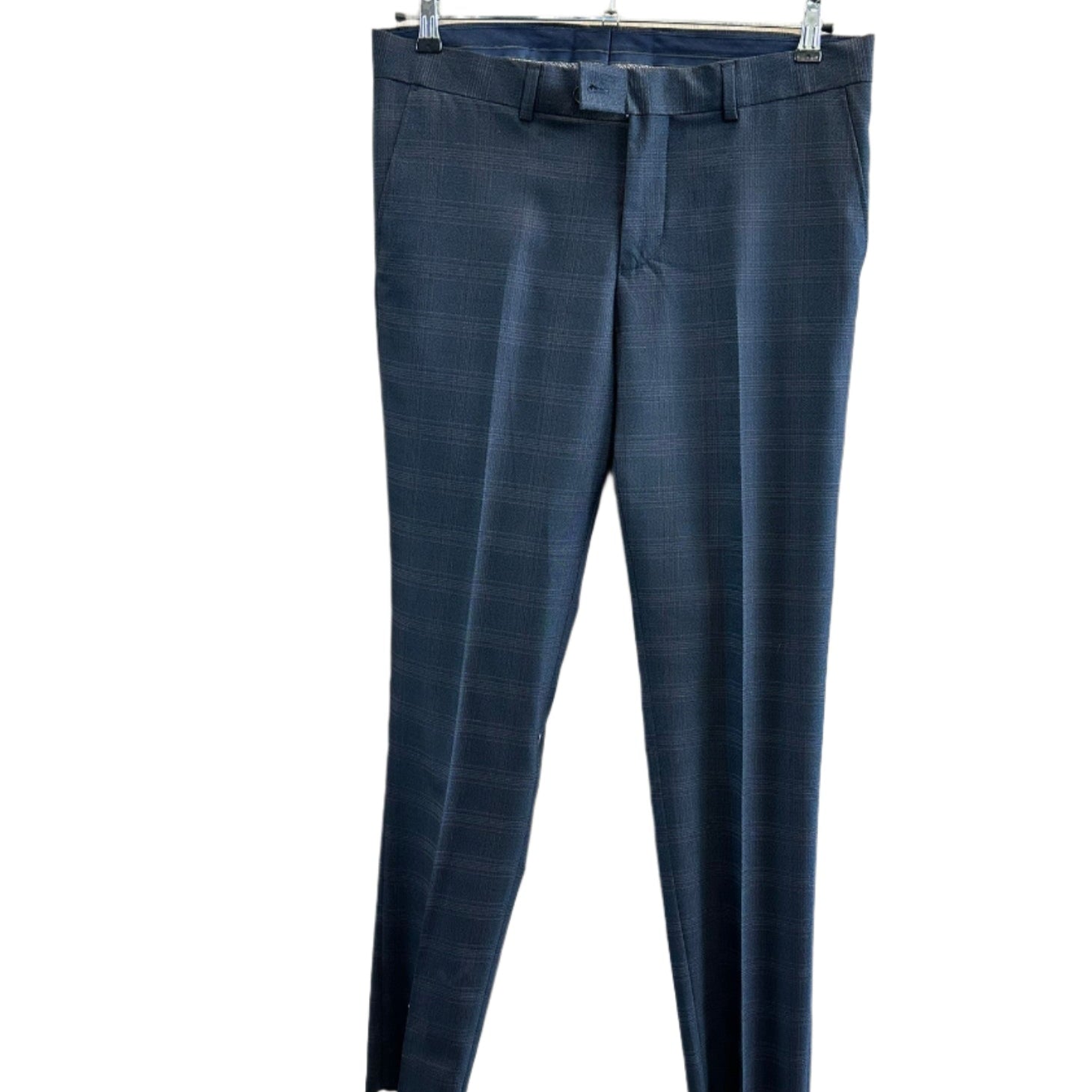 Tamsiai mėlynos vyriškos kelnės su langeliais, pakabintos ant pakabos