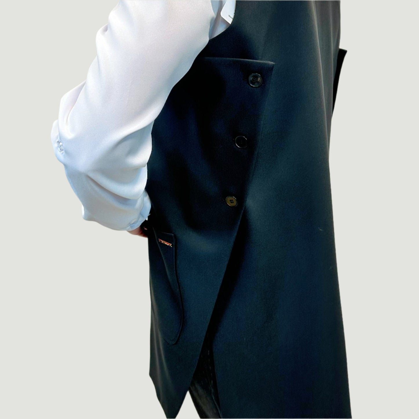 Ilgos juodos liemenės šoninis vaizdas su matomomis dekoratyvinėmis sagomis