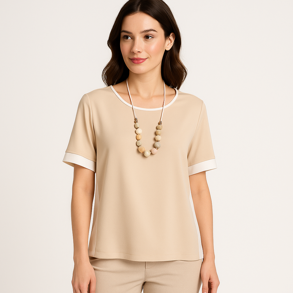 Modelis dėvi smėlio spalvos palaidinę su minimalistiniu dizainu ir subtiliomis šviesiomis detalėmis.