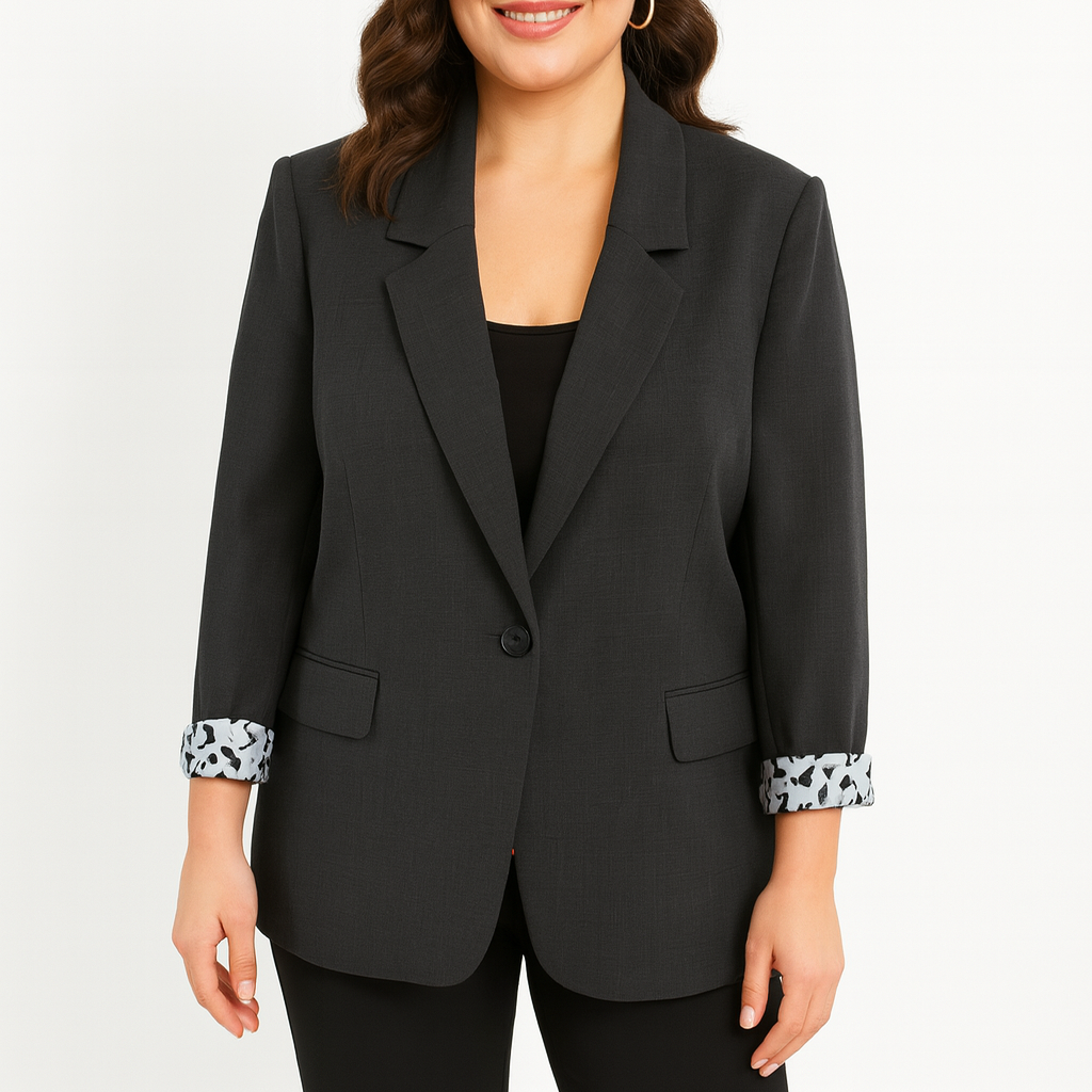 Modelis dėvi pilką ilgesnio kirpimo moterišką švarką su raštuotais rankogaliais, rodomas priekis ir siluetas.