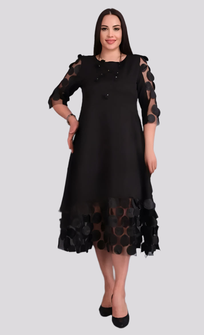 Stilinga ir elegantiška juoda suknelė su unikaliais dekoratyviais apskritimais ant rankovių ir apačios. Suknelė lengvai krentanti, pabrėžia siluetą, bet nevaržo judesių. Idealiai tinka šventėms, vakarėliams ar ypatingoms progoms