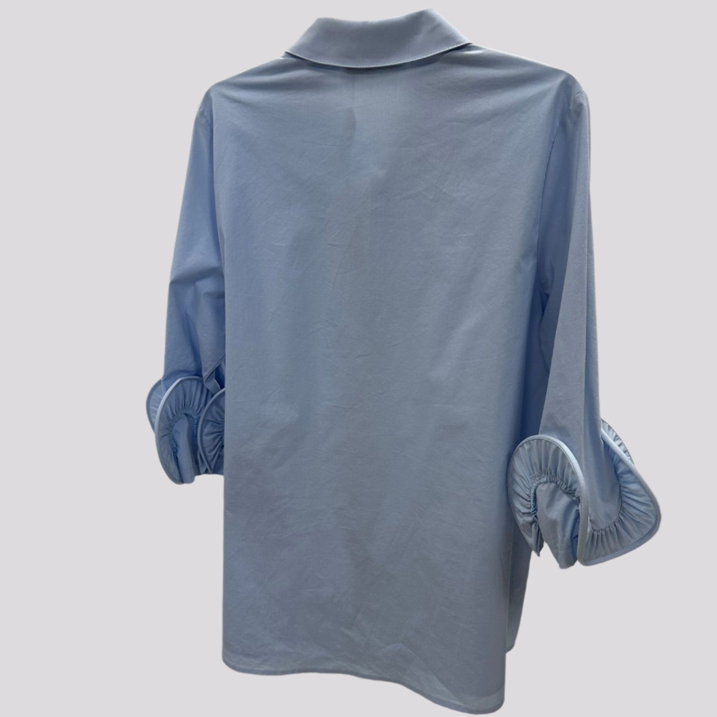 Žydri klasikiniai moteriški marškiniai su dekoruotomis rankovėmis, pakabinti ant pakabos.