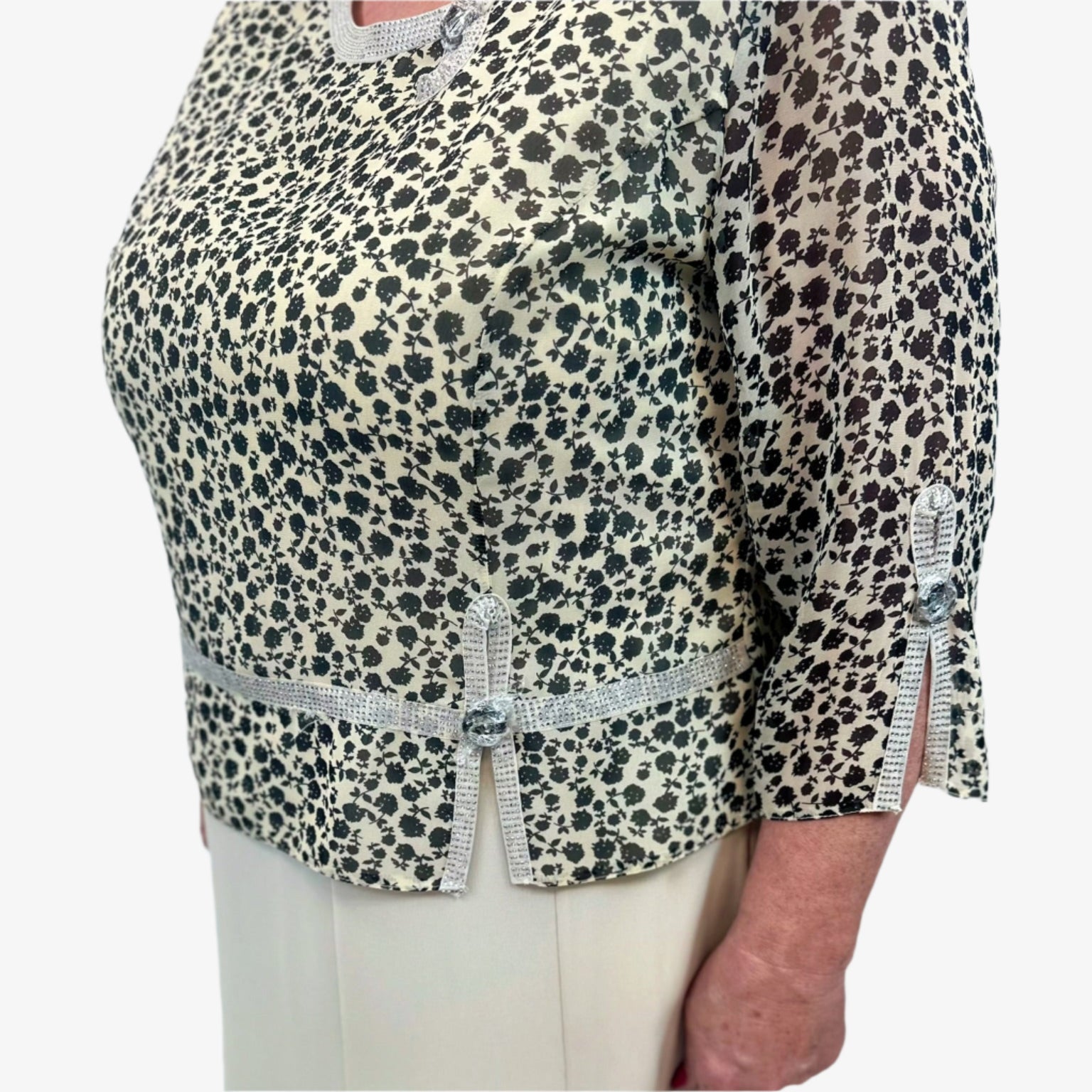 Žėrinti apykaklė ir 3/4 rankovės suteikia šiai suknelei unikalumo ir elegancijos.