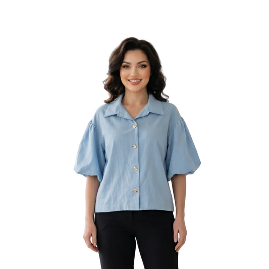 Woman wearing a light blue blouse with a blurred window background