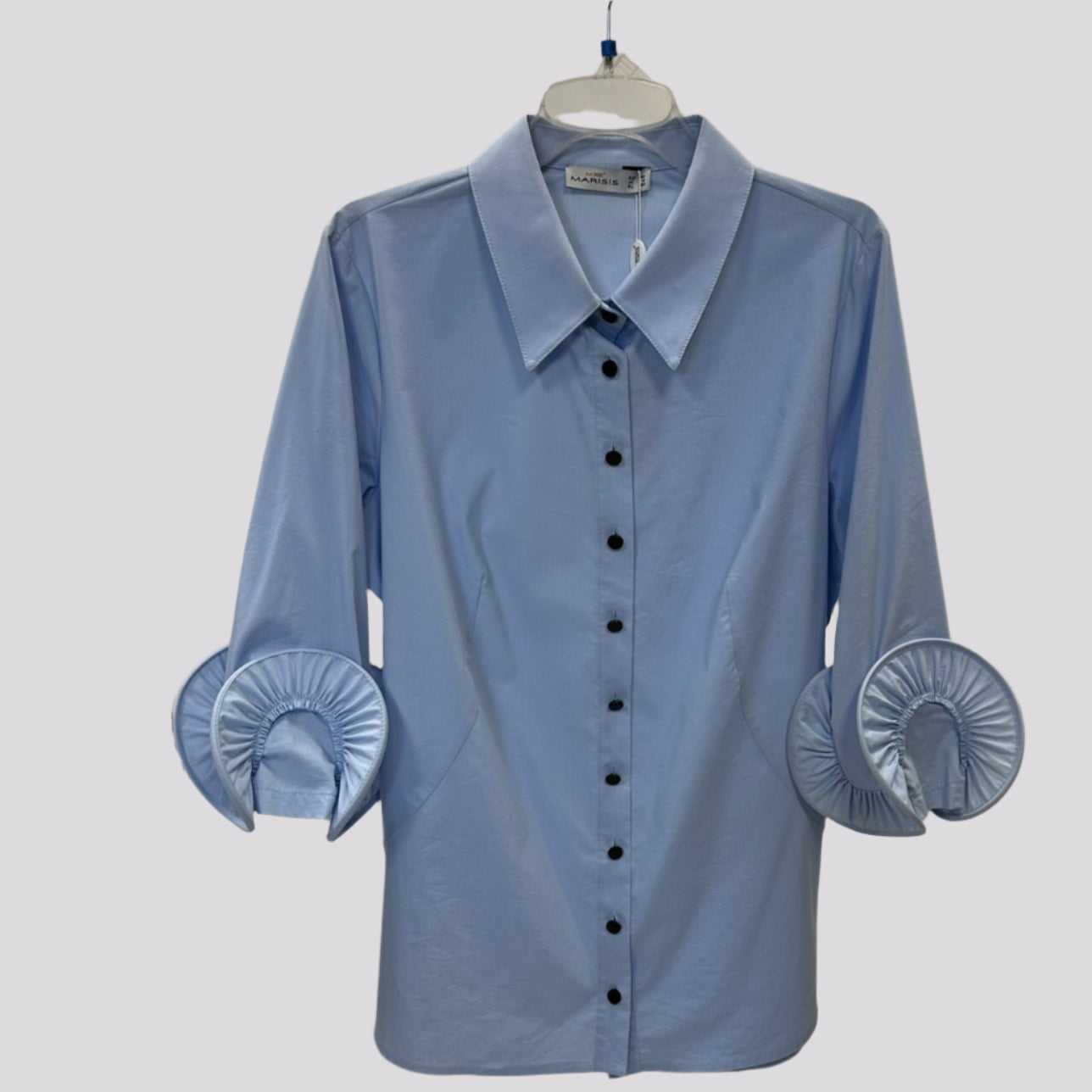 Žydri klasikiniai moteriški marškiniai su dekoruotomis rankovėmis, pakabinti ant pakabos.