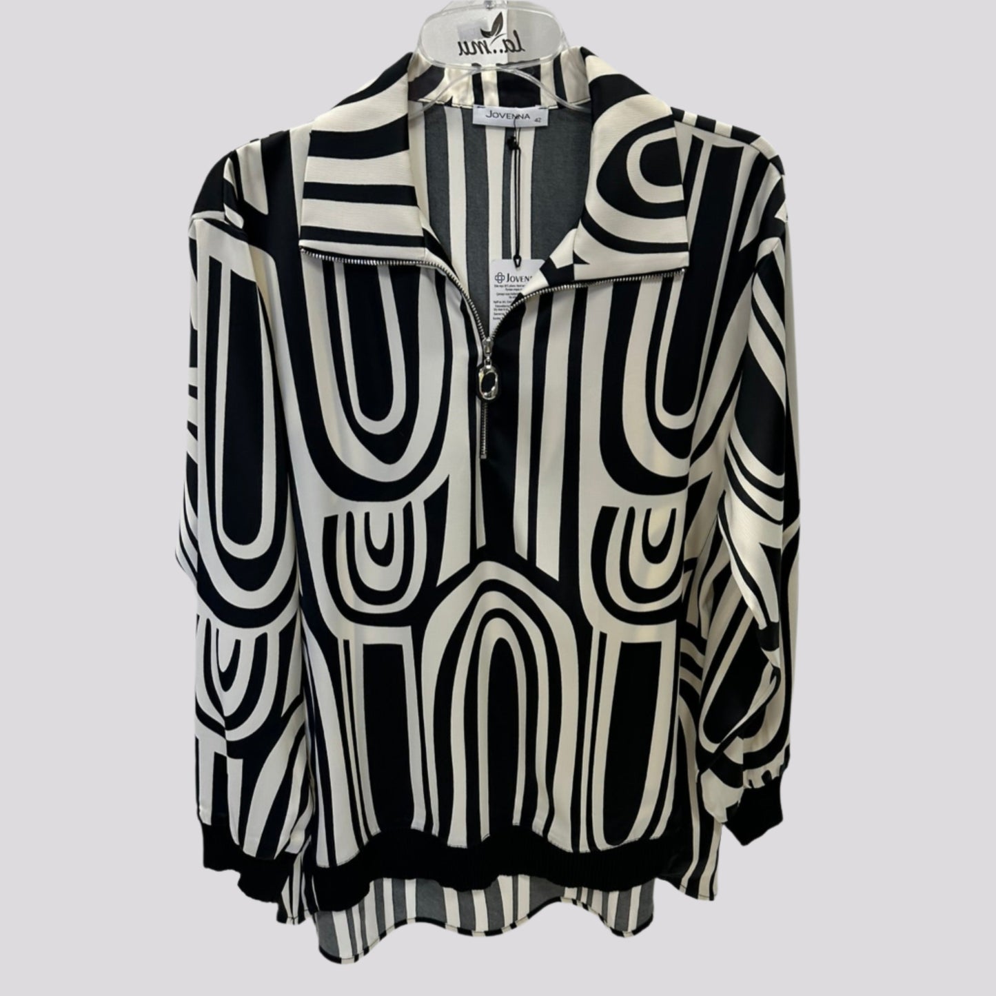 Stilinga kreminė palaidinė ant pakabos su kontrastingais akcentais, švelniai krentantis audinys.