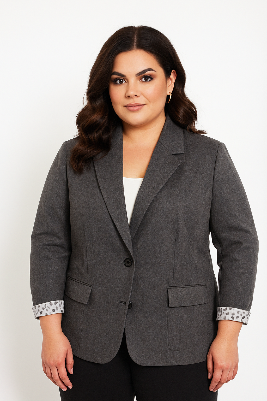 Woman wearing a gray blazer with patterned cuffs on a white background